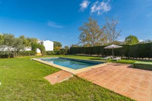 a swimming pool in a yard with an umbrella at Cubo's Casa Rural Cortijo del Puntal in Teba