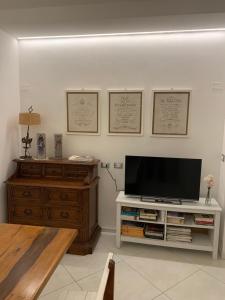 a living room with a flat screen tv on a wooden dresser at Casa Due Cuori - Massa Centro in Massa