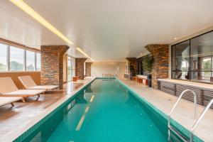 an indoor swimming pool with chairs and a swimming pool at Premium Modern Studio in Alphaville in Santana de Parnaíba