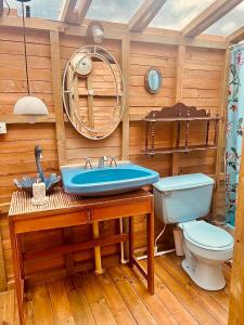 a bathroom with a blue sink and a toilet at Chalets HUITACA in Choachí