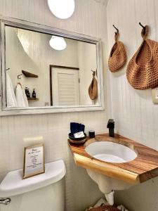 un bagno con lavandino, specchio e WC di Couples Cottage - Serene Getaway a Reddick Altre 69 foto