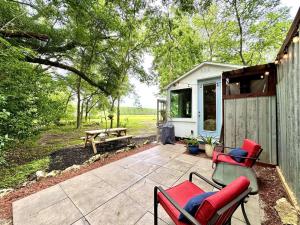 un patio con sedie, una panca e una tettoia di Couples Cottage - Serene Getaway a Reddick