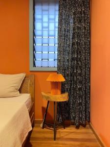 a bedroom with a bed and a table next to a window at The Urban Farm House in Accra