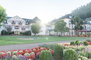 a large white building with flowers in a park at Hotel Fürstenhof Bad Bertrich in Bad Bertrich