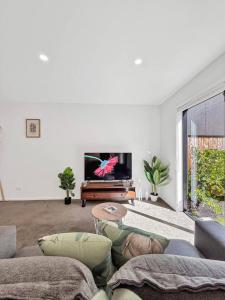 a living room with a couch and a flat screen tv at Stylish 2-Bedroom Home with Front Yard in Linwood