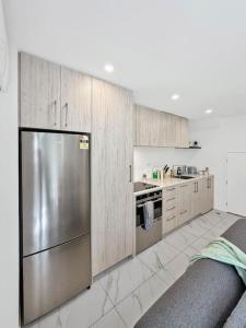 a kitchen with a stainless steel refrigerator and cabinets at Stylish 2-Bedroom Home with Front Yard in Linwood