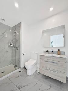 a bathroom with a toilet and a shower and a sink at Stylish 2-Bedroom Home with Front Yard in Linwood +17 photos