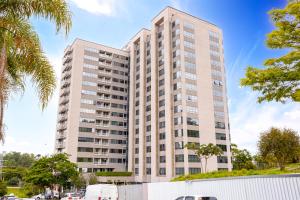 a tall white building with trees in front of it at Premium Modern Studio in Alphaville in Santana de Parnaíba