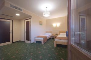 um quarto de hospital com duas camas e um corredor em Advenus Hotel em Lviv