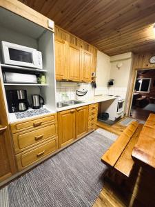 eine Küche mit Holzschränken und einer Arbeitsplatte in der Unterkunft Cleanest air Kuorikki-Wilderness in Suulari + 20 Fotos