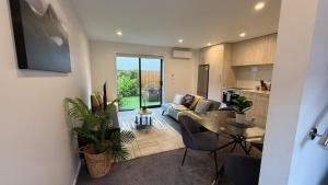 a living room with a couch and a table at Stylish Cashel Townhouse Stay in Linwood