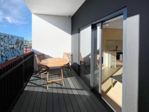 Chic 1-Bedroom Apartment with Balcony in Ferry Rd في Linwood: بلكونه عليها طاوله ومطبخ