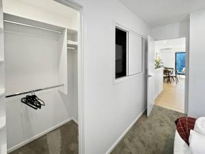 Chic 1-Bedroom Apartment with Balcony in Ferry Rd في Linwood: ممر مع باب أبيض وغرفة معيشة