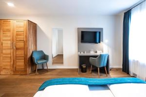 a bedroom with a bed and a desk and a tv at Gasthaus Adler Konstanz in Konstanz