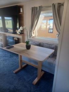 a living room with a table and a couch at 63 The Pastures Tattershall lakes in Lincoln