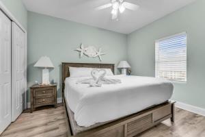 Un dormitorio blanco con una cama y un ventilador de techo. en Laketown Wharf 1331, en Panama City Beach