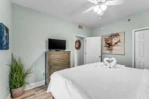 Un dormitorio con una cama blanca y un televisor. en Laketown Wharf 1331, en Panama City Beach