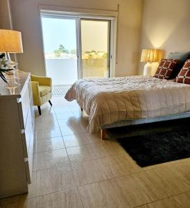 Un dormitorio con una cama y una ventana grande. en Summertime, en Porches