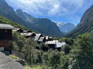 Mountain house with two barns and a garden في Planay: مجموعة منازل في وادي مع جبال