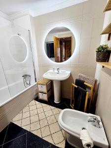 Un baño con lavabo, bañera y espejo. en Summertime, en Porches