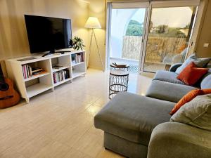 a living room with a couch and a flat screen tv at Summertime in Porches