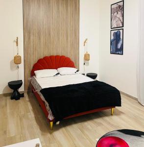 ein Schlafzimmer mit einem großen Bett mit orangefarbenem Kopfteil in der Unterkunft Msuite in Giarre