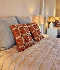 Una cama con dos almohadas y dos lámparas. en Summertime, en Porches 14 fotos más