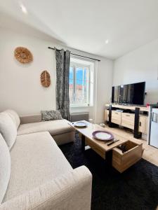 a living room with a couch and a table at Harmony in Limonest +1 photo