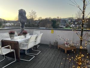 a patio with a table and chairs on a deck at Ferienwohnung Lang in Nümbrecht