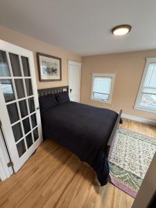 a bedroom with a bed with a black blanket at The Coastal Connection in South Portland