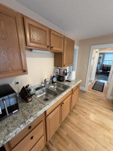 a kitchen with wooden cabinets and a sink at The Coastal Connection in South Portland