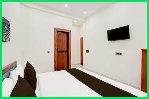 une chambre avec un lit et une télévision au mur dans l'établissement Hotel Mahaveera Galaxy Inn Near Kashi Vishwanath Temple - Restaurants # Free Wi-Fi And Parking Facilities - Fully Air conditioning Room- Best Hotel In Varanasi, à Varanasi