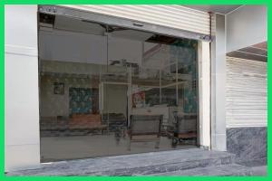 une fenêtre en verre d'un bâtiment avec des chaises à l'intérieur dans l'établissement Hotel Mahaveera Galaxy Inn Near Kashi Vishwanath Temple - Restaurants # Free Wi-Fi And Parking Facilities - Fully Air conditioning Room- Best Hotel In Varanasi, à Varanasi