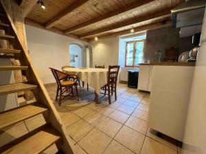 Mountain house with two barns and a garden في Planay: مطبخ وغرفة طعام مع طاولة وكراسي