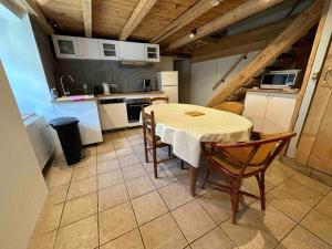 Mountain house with two barns and a garden في Planay: مطبخ مع طاولة وكراسي في الغرفة +34 صورة