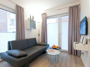 una sala de estar con un sofá y una mesa en Palais Garteneck 4, en Norderney