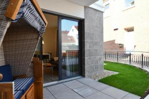 Un patio con puertas corredizas de vidrio y un patio. en Palais Garteneck 4, en Norderney 1 foto más