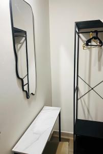 Eine weiße Wand mit einem Tisch und einem Glaskühlschrank in der Unterkunft Msuite in Giarre