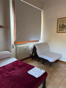 a room with two beds and a chair and a window at RUS Apartment in Florence