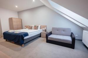 ein Schlafzimmer mit einem Bett und einem Stuhl in der Unterkunft Hotel Garbów *** Centrum Konferencyjno - Bankietowe in Garbów