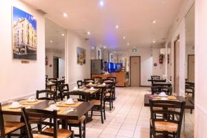 une salle à manger avec des tables et des chaises dans un restaurant dans l'établissement Hotel Ours Blanc - Victor Hugo, à Toulouse
