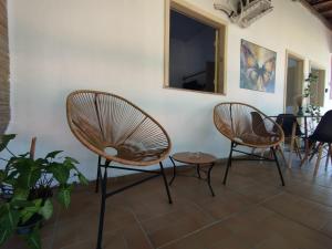 2 chaises et un miroir sur un mur dans l'établissement Sunset Flats - Bonito Flat na Rua Pituba 1 , bem perto das praias urbanas! Itacare BA 2, à Itacaré