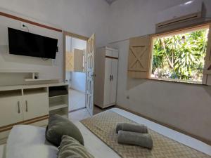 un salon avec un canapé et une fenêtre dans l'établissement Sunset Flats - Bonito Flat na Rua Pituba 1 , bem perto das praias urbanas! Itacare BA 2, à Itacaré