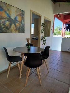 une table et des chaises dans une pièce ornée d'une peinture aux papillons dans l'établissement Sunset Flats - Bonito Flat na Rua Pituba 1 , bem perto das praias urbanas! Itacare BA 2, à Itacaré