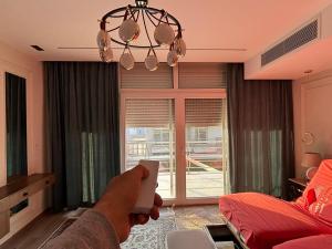 eine Person, die in einem Wohnzimmer eine Wii-Fernbedienung hält in der Unterkunft 7 BR Smart House with Heated Pool, Waterfall, Garden in Kairo