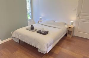 a bedroom with a bed with two hats on it at Du soleil au balcon - Hypercentre in Lons-le-Saunier