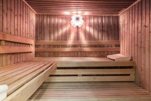 a wooden sauna with two benches and a clock at Haus Weesterhuk, Whg 8 Jopi Keitum in Keitum
