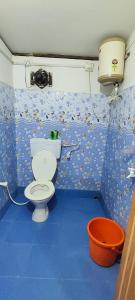 une salle de bain avec toilettes et sol bleu dans l'établissement AALTAPORI HOMESTAY- BEST HOMESTAY in BUXA-JAYANTI, à Jayanti