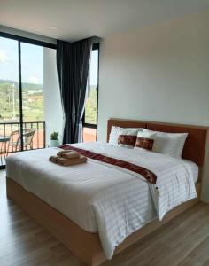 ein Schlafzimmer mit einem großen Bett mit einem großen Fenster in der Unterkunft Ck Home Lanta in Phra Ae beach