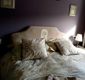 Una cama con almohadas en un dormitorio. en Spacious Annexe in central Colchester, en Lexden